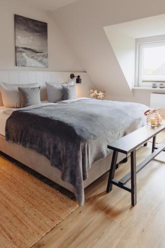 a bedroom with a large bed and a table at Seetiid in Westerland (Sylt)