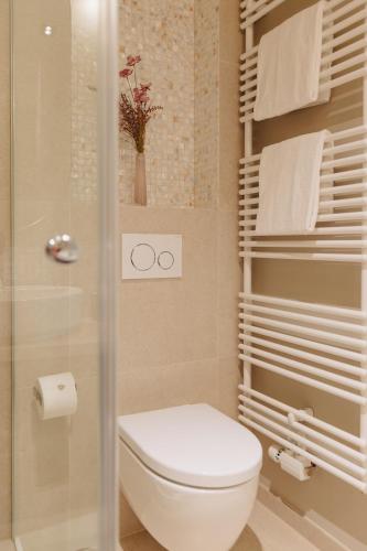 a bathroom with a toilet and a shower with towels at Seetiid in Westerland (Sylt)