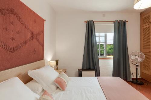 a bedroom with a white bed and a window at La Casa Amarilla in El Paso