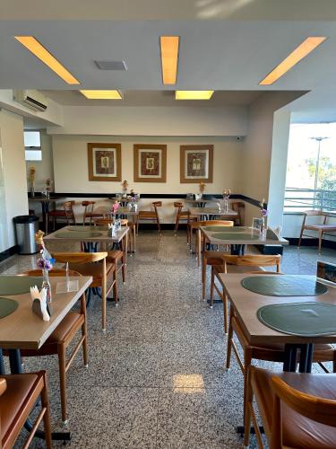 an empty dining room with tables and chairs at Hotel Atlas in Sete Lagoas