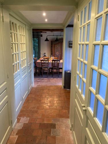 un couloir avec une salle à manger avec une table dans l'établissement Chaumière de famille, à Saint-Pierre-de-Cormeilles