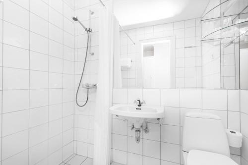 a white bathroom with a sink and a shower at Olden Fjordhotel in Olden