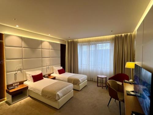 a hotel room with two beds and a flat screen tv at Hotel Mepas in Mostar