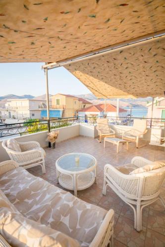 a patio with chairs and a table on a balcony at Ten Suns Downtown B by 8essentially in Lixouri