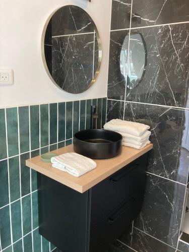 a bathroom with a black sink and two mirrors at La marine D'opale in Ambleteuse