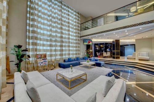 a living room with a couch and a pool at Lotus Grand Hotel in Dubai