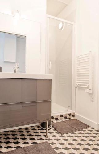 une salle de bain blanche avec un lavabo et un miroir dans l'établissement Appartement calme et neuf au coeur de Lyon, à Lyon