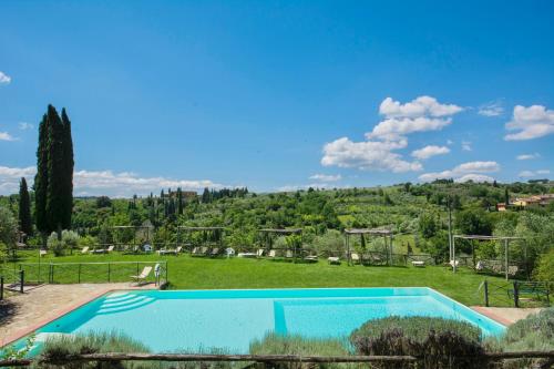 a swimming pool in a grassy field with a mountain at THR-Apartment with 2 bedrooms, 5 beds, 2 bathrooms, air conditioning and private outdoor space in a residence with swimming pool not far from Florence in Grassina