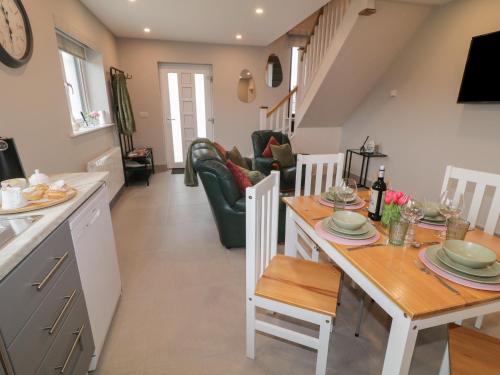 a kitchen and living room with a table and chairs at Ard Na Ghaoithe in Loughanure