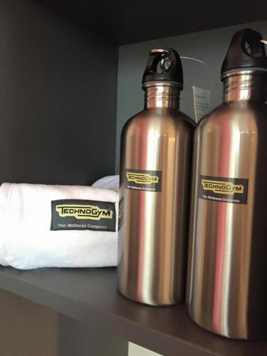 two metal water bottles are sitting on a shelf at Hotel Petrarca in Boara Pisani