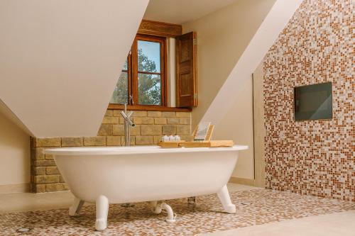 a bathroom with a white tub and a tv at South Lodge in Lower Beeding