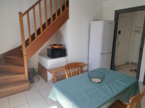 Il comprend une cuisine avec une table et un réfrigérateur. dans l'établissement l'Escale, à Thoissey