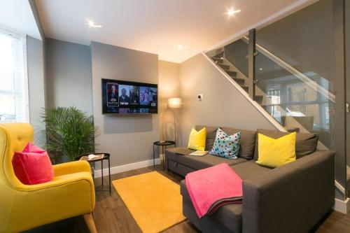a living room with a couch and a tv at Stylish home close to the BEACH By Adliv in Margate