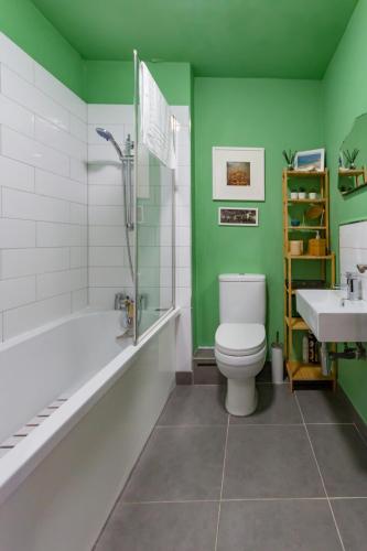 a bathroom with a tub and a toilet and a sink at Walpole Bay 2 bed Stunning Garden Apt By Adliv in Margate