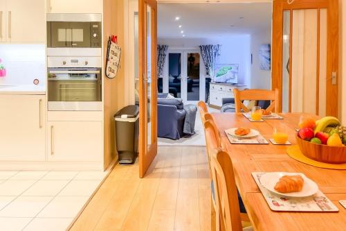 a kitchen and living room with a wooden table with fruit on it at Stylish Coastal Home, Pets & Parking By Adliv in Margate