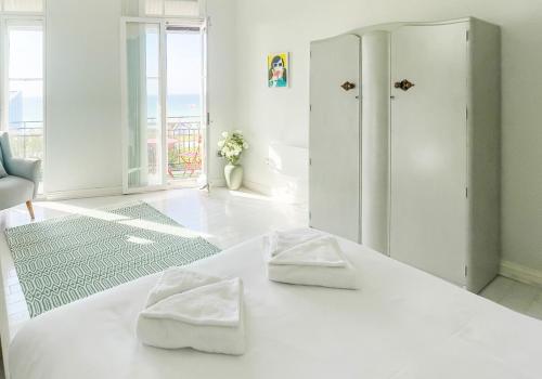 a white room with two towels sitting on a bed at Seaview Apt Turner Contemporary, Margate By Adliv in Margate