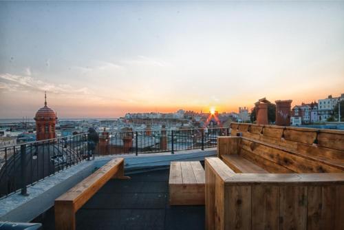 a bench on a balcony with a view of a city at Rooftop Terrace with Harbour Views By Adliv in Ramsgate