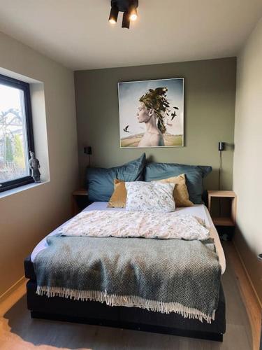 a bedroom with a bed and a picture on the wall at Villa på Jeløya in Moss