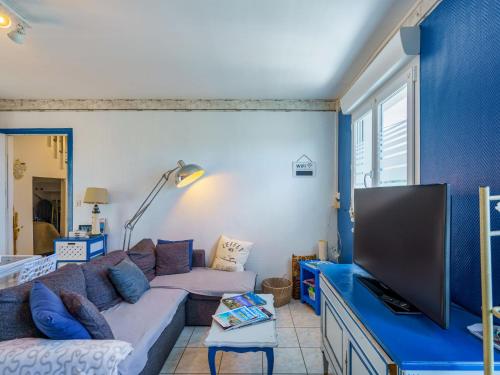 un salon avec un canapé et une télévision à écran plat dans l'établissement Holiday Home la maison du bonheur by Interhome, à Primelin
