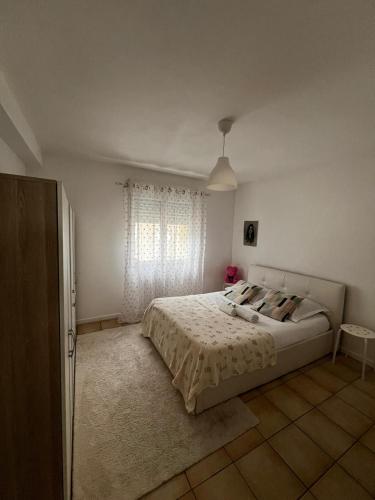 une chambre blanche avec un lit et une fenêtre dans l'établissement Calme, à Sannois