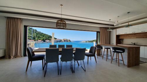 a dining room with a table and chairs and a large window at Augusta in Lastovo