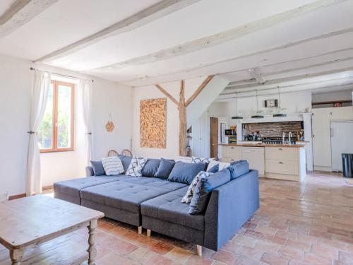 un salon avec un canapé bleu et une table dans l'établissement Holiday Home Larroque Haute by Interhome, à Bourlens