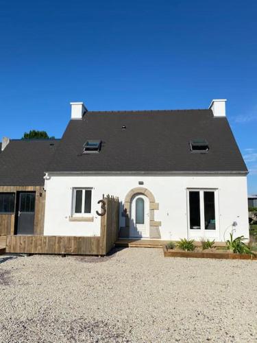 a white house with a black roof at En vacances Simone ! in Plurien