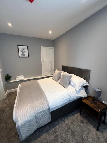a bedroom with a large bed and a table at The Globe Apartments in Cockermouth