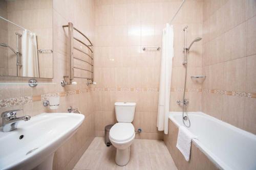 a bathroom with a toilet and a tub and a sink at Optima Odesa in Odesa
