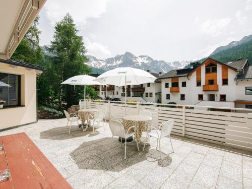 a patio with tables and chairs and umbrellas at Apartment Olympia by Interhome in Solda