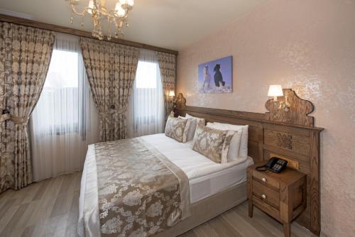 a bedroom with a large bed and a chandelier at Perapolis Hotel in Istanbul