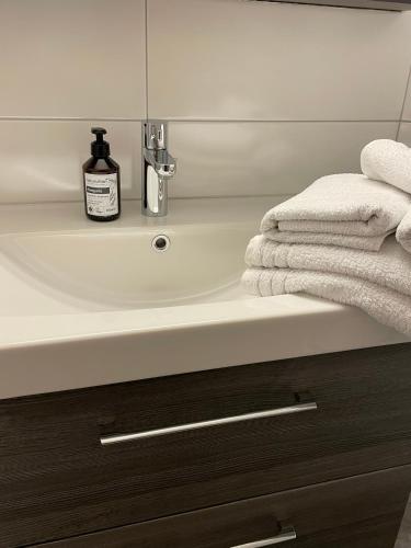 a bathroom sink with a bottle of soap and towels at Gästehaus Brugger in Hermagor
