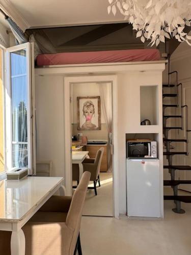 - un salon avec un réfrigérateur blanc et une table dans l'établissement Joli studio avec mezzanine centre Cannes, à Cannes