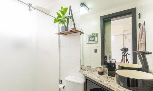 a bathroom with a sink and a mirror at Loft no coração da cidade de Blumenau in Blumenau