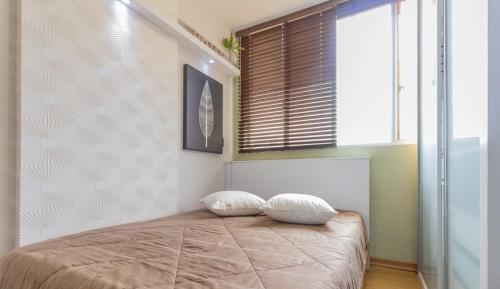 a bedroom with a bed with two pillows on it at Loft no coração da cidade de Blumenau in Blumenau