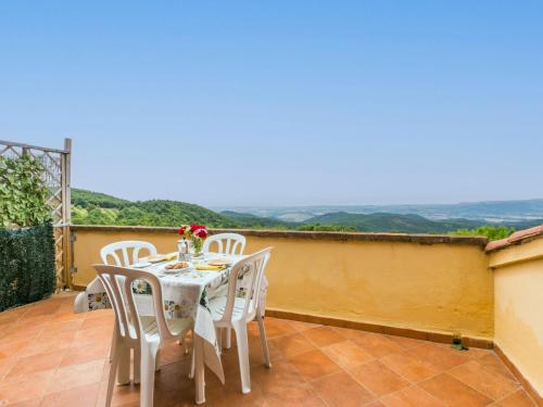 a table and chairs on a patio with a view at Apartment Bellavista-2 by Interhome in Castellina Marittima