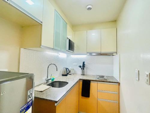 une petite cuisine avec un évier et un comptoir dans l'établissement Mactan cozy staycation, à Lapu Lapu City