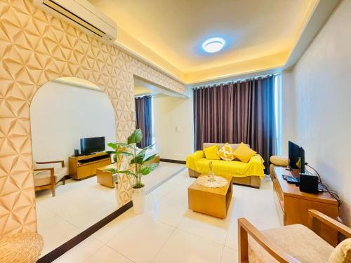- un salon avec un canapé jaune et une télévision dans l'établissement Mactan cozy staycation, à Lapu Lapu City
