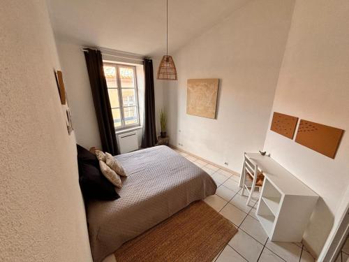 une chambre avec un lit, un bureau et une fenêtre dans l'établissement Charming Carcassonne Duplex, à Carcassonne