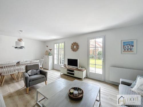 un salon blanc avec un canapé et une table dans l'établissement La Maison La Brise Bleue, Jardin, Garage, 400m Plage, à Bray-Dunes