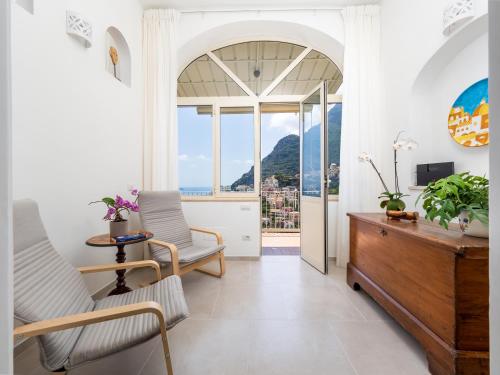 a living room with a table and chairs and a window at Casa Vittorina - De Vivo Realty Positano in Positano