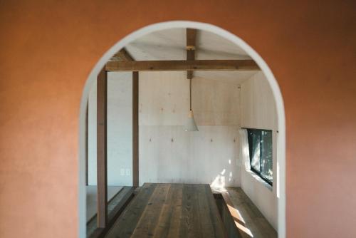 an arched doorway to a room with an orange wall at Villa Yumigahama in Minamiizu