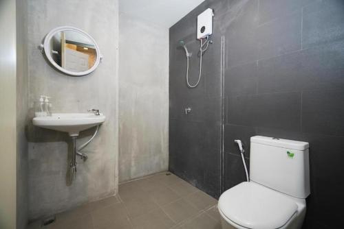 Un baño con inodoro, lavabo y espejo. en GO INN BTS ST Louis Silom - โกอินน์ บีทีเอส เซนต์หลุยส์ สีลม 4, en Yan Nawa