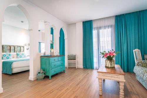 a bedroom with a blue dresser and a bed and a table at La Residencia Puerto Hotel & Spa in Tarifa