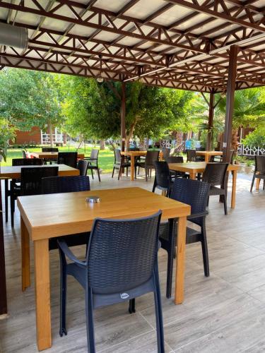 a wooden table and chairs under a pergola at Villa Efsane Hotel in Cıralı