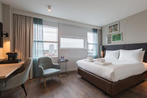 a hotel room with a bed and a desk and a chair at Crowne Plaza Utrecht - Central Station by IHG in Utrecht