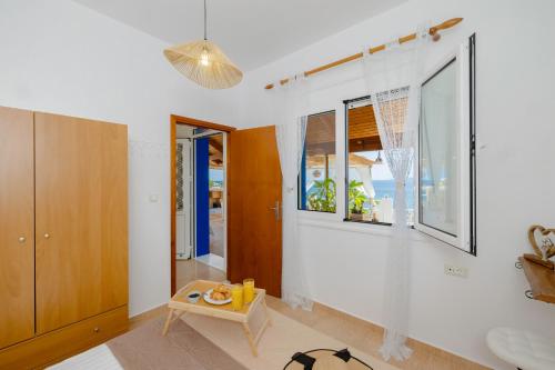 a room with white walls and windows and a table at Korali Sea House in Archangelos
