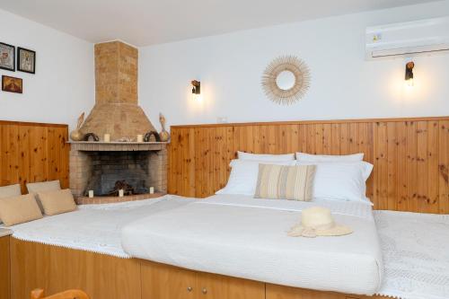 a bedroom with a large bed with a fireplace at Korali Sea House in Archangelos