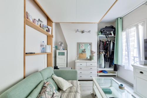 un salon avec un canapé et une table en verre dans l'établissement Cosy studio proche du Canal Saint-Martin, à Paris