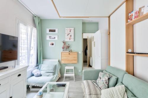 un salon avec un canapé et une chaise dans l'établissement Cosy studio proche du Canal Saint-Martin, à Paris
